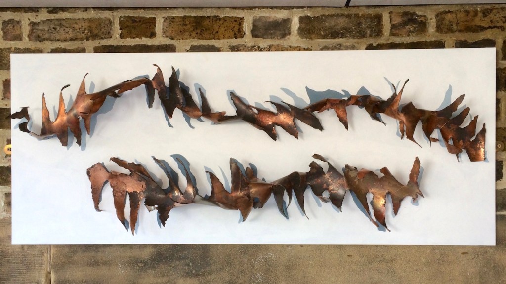 Spines - Deconstructed copper tubes create 2 jagged spiky edge spines mounted horizontally on white painted board. 1.2 x 0.5 meters.