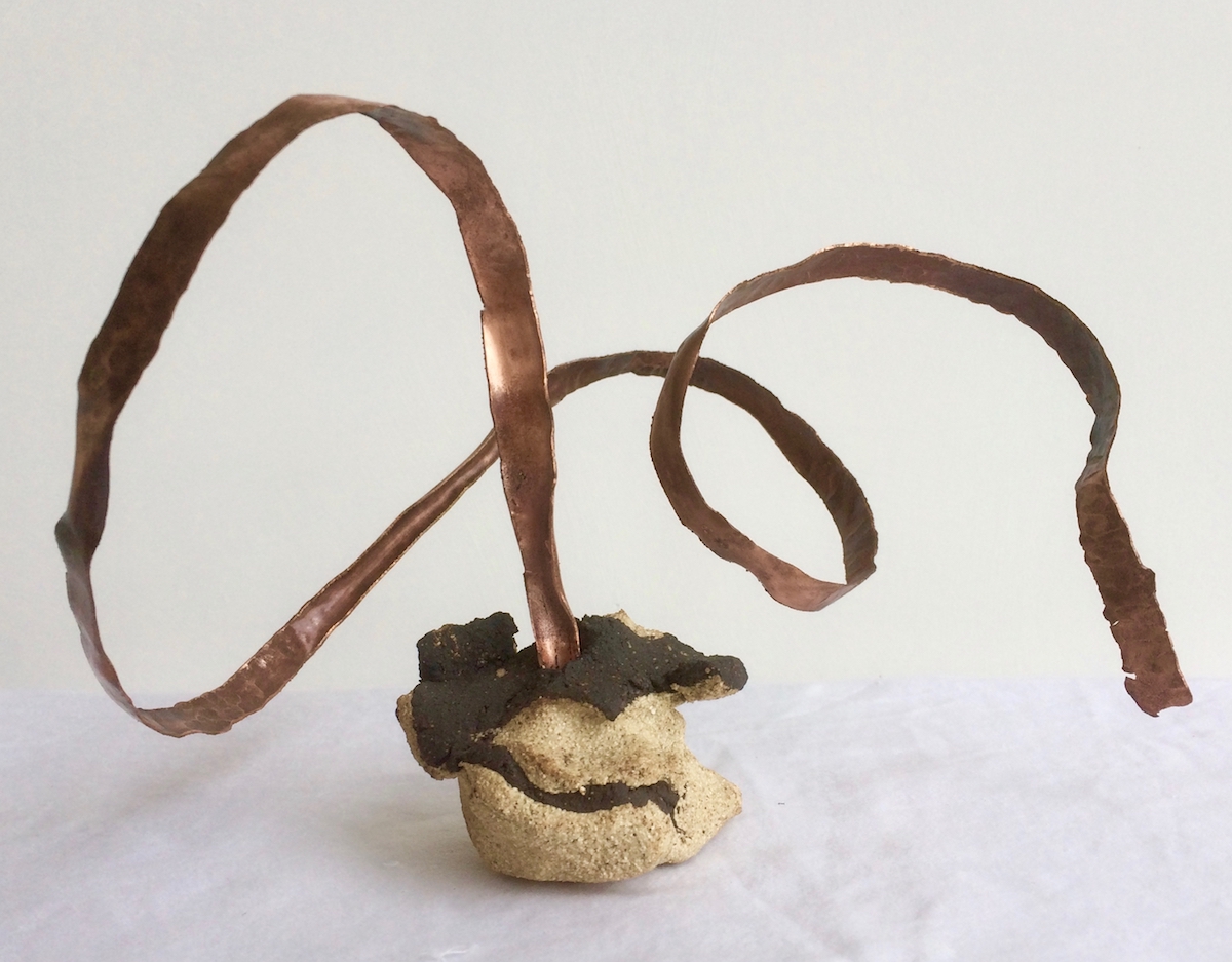 Twisted Coper ribbon erupts from black and cream stoneware blob.